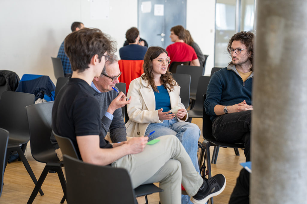 a group of students and faculty members discussing in a cercle